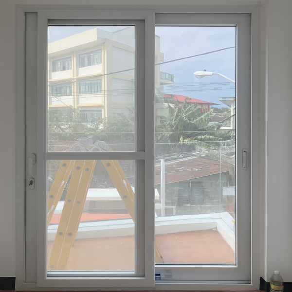 White UPVC Sliding Door | Balcony View | LuckyHome Philippines White UPVC sliding door with clear glass opening to balcony view – elegant, durable, and weatherproof design by LuckyHome Philippines
