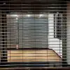 Stainless 316 grill type roll up door installed in a commercial showroom, featuring polished steel bars, manual and motorized operation options by LuckyHome Philippines.